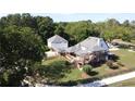 Aerial view highlighting the expansive deck, outbuildings, and well-maintained landscaping surrounding the beautiful white home at 3898 Ridge Rd, Buford, GA 30519