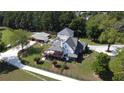 Aerial view of a stunning property featuring a large home, extended deck, and outbuildings surrounded by green landscape at 3898 Ridge Rd, Buford, GA 30519