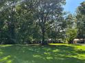 Ranch home surrounded by tall trees, sunny day at 5595 Stagecoach Rd, Rex, GA 30273