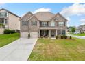 Charming two-story brick home with well-manicured front yard and attached two-car garage at 5410 Whisper Ct, Cumming, GA 30028
