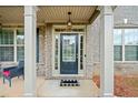 Inviting front porch with classic columns and stylish black door, creating curb appeal at 5410 Whisper Ct, Cumming, GA 30028