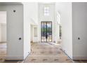 Bright foyer with high ceilings, black framed glass doors, and modern design elements at 235 River Valley Court Lot 4 Ct, Atlanta, GA 30328