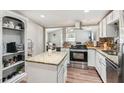 Well-lit kitchen features stainless steel appliances, an island, granite countertops and backsplash at 5365 Crow Rd, Cumming, GA 30041