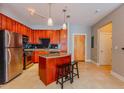 Kitchen featuring an island, tile floors, stainless steel appliances, and wood cabinets at 799 Hammond Dr # 406, Atlanta, GA 30328