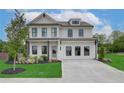 Two-story home with white brick exterior, landscaping and a large driveway at 4493 Eastbrook Pl, Snellville, GA 30039