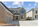 Beautiful new construction home featuring a brick and siding facade with an attached two-car garage at 102 Cottage Gate Ln, Roswell, GA 30076
