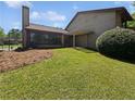 Lush backyard offering a green lawn, mature trees, and a covered patio at 1084 Village Main St, Stone Mountain, GA 30088