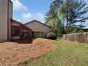 Spacious backyard featuring a green lawn, mature trees, and a covered patio at 1084 Village Main St, Stone Mountain, GA 30088