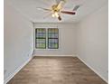 A bright bedroom features a ceiling fan and two windows that let in natural light at 1084 Village Main St, Stone Mountain, GA 30088