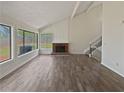 Bright living room with vaulted ceiling, brick fireplace, large windows, and hardwood floors at 1084 Village Main St, Stone Mountain, GA 30088