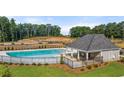Aerial view of a community pool with a clubhouse and seating area, surrounded by well-manicured landscaping at 338 Elgin Dr, Lawrenceville, GA 30045
