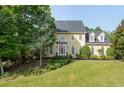 Traditional two-story home has a manicured lawn and mature landscaping at 1357 Baniff Ct, Snellville, GA 30078