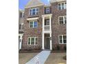 Charming brick townhome with a covered front entrance and manicured landscaping at 1956 Deco Dr, Kennesaw, GA 30144