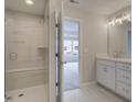 Bright bathroom featuring a glass enclosed shower with seat, white cabinets, and marble floors at 1976 Deco Dr, Kennesaw, GA 30144