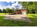 Rear exterior view of a two-story brick home with an attached garage and a spacious driveway at 1417 Iris Lake Rd, Mcdonough, GA 30252