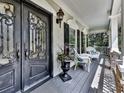 Charming front porch with white chairs and ornate door at 1012 Jubilee Way, Powder Springs, GA 30127