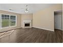 Spacious living room with hardwood flooring, fireplace, ceiling fan, and lots of natural light at 424 Eglington Trl, Locust Grove, GA 30248