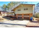 Side view of a ranch home with brick and siding exterior and a two-car garage at 5620 Orly Ter, College Park, GA 30349