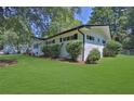 Ranch style home with a well-manicured lawn and mature trees at 4340 W Linda Dr, Douglasville, GA 30134
