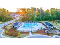 Aerial view of community pool featuring lounge area, picnic shelter, playground, and manicured landscaping at 570 Silver Moon Dr, Loganville, GA 30052