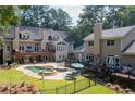 Expansive backyard featuring a swimming pool, spa, multiple decks, and ample seating areas at 2010 Stonehedge Rd, Roswell, GA 30075