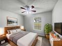 Cozy bedroom with a ceiling fan, a window, and a plant on the dresser at 3384 Brookside Ln, Jonesboro, GA 30236