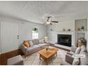 Comfortable living room featuring a fireplace, ceiling fan, and stylish decor at 3384 Brookside Ln, Jonesboro, GA 30236