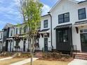 Elegant townhomes with white exteriors, dark window accents, and landscaped front yards at 630 Skytop Dr # 157, Cumming, GA 30040