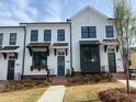 Charming townhome showcasing white siding, black trim, covered entryways, and brick stairs at 630 Skytop Dr # 157, Cumming, GA 30040