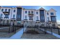 Charming three-story townhome with landscaped front yard and dark metal fence at 621 Silva St # 124, Cumming, GA 30040