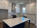 Bright kitchen featuring white cabinets, stainless steel appliances, and a center island with a white countertop at 635 Skytop Dr, Cumming, GA 30040