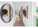 Bright entry hall with hardwood floors, large mirror, and modern wall art at 5756 Tillman Way, Powder Springs, GA 30127