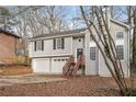 Gray house with wooden stairs and a two-car garage, surrounded by trees at 2920 Cushing Ct, Jonesboro, GA 30236