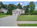 Inviting home with a long driveway, attached garage, and lush front lawn at 1215 Wandering Vine Ct, Mableton, GA 30126