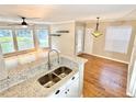 An open-concept kitchen with a double sink, granite countertop, and stainless steel faucet at 406 Hawkstone Way, Alpharetta, GA 30022