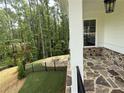 Enjoy this covered porch with stone flooring and a fire pit, perfect for relaxation at 1065 Low Water Nw Xing, Acworth, GA 30101
