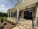 Inviting front porch with stone base, sturdy black railings, and charming pendant lights, offering a warm welcome at 1065 Low Water Nw Xing, Acworth, GA 30101