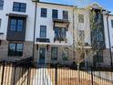 Townhomes featuring white brick, dark trim, well-manicured lawn and a black metal fence at 629 Silva St # 128, Cumming, GA 30040