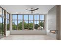 Bright living room featuring a modern fireplace, ceiling fan, and large windows with a scenic view at 8200 Main St # 1206, Woodstock, GA 30188