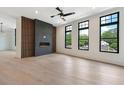 Modern living room with a fireplace, accent wall, and large windows overlooking greenery at 8200 Main S St # 1208, Woodstock, GA 30188