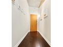Hallway with hardwood floors leading to a front door and artwork on the walls at 923 Peachtree Ne St # 927, Atlanta, GA 30309