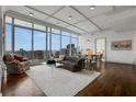 Sunlit living room boasts city views, modern decor, hardwood floors, and an open layout into the dining area at 1065 Peachtree Ne St # 3003, Atlanta, GA 30309