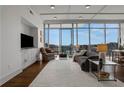 Bright and airy living room featuring floor-to-ceiling windows with city views, hardwood floors, and modern furnishings at 1065 Peachtree Ne St # 3003, Atlanta, GA 30309