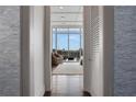 View of a modern living room through an open doorway, featuring large windows with city views and stylish decor at 1065 Peachtree Ne St # 3003, Atlanta, GA 30309