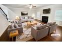 This is a bright living room with a fireplace, a ceiling fan, and stairs leading to the upper floor at 3650 Lindsy Brooke Ct, Douglasville, GA 30135