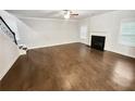 Spacious living room with hardwood floors, a fireplace, a ceiling fan, and stairs leading to the upper floor at 3650 Lindsy Brooke Ct, Douglasville, GA 30135