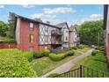 A multi-story condo building shows a combination of brick and Tudor design, accented by well-maintained lawns and green hedges at 6851 Roswell Rd # E1, Atlanta, GA 30328