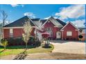 Charming brick home featuring an attached garage, lush landscaping, and a welcoming driveway at 3240 Somerset Se Ct, Conyers, GA 30013