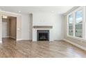 Bright living room features a modern fireplace and large windows with backyard views at 5225 Ginger Rose Ct, Cumming, GA 30028
