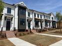 Modern townhomes boast sleek architectural details, complemented by brick steps and lush green lawns at 628 Skytop Dr # 158, Cumming, GA 30040